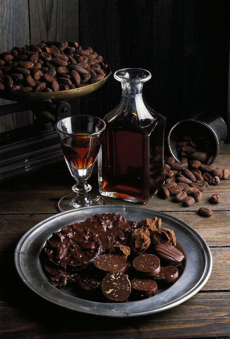 Schokoladenauswahl auf Zinnteller mit Madeira, Kakaobohnen im Hintergrund