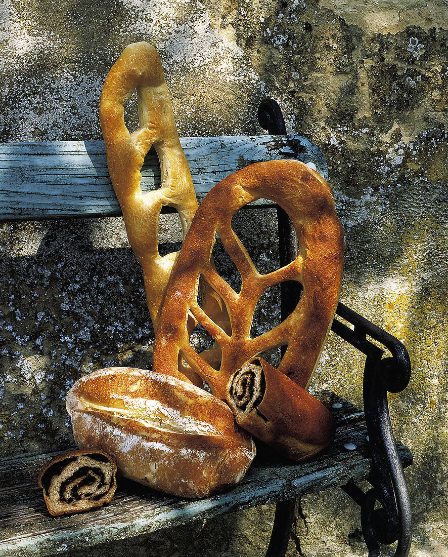 Verschiedene Brote auf einer alten Holzbank im Freien