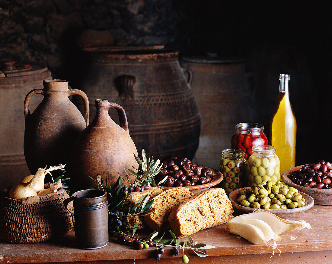 Mediterranes Stillleben mit Oliven, Brot und Tonkrügen