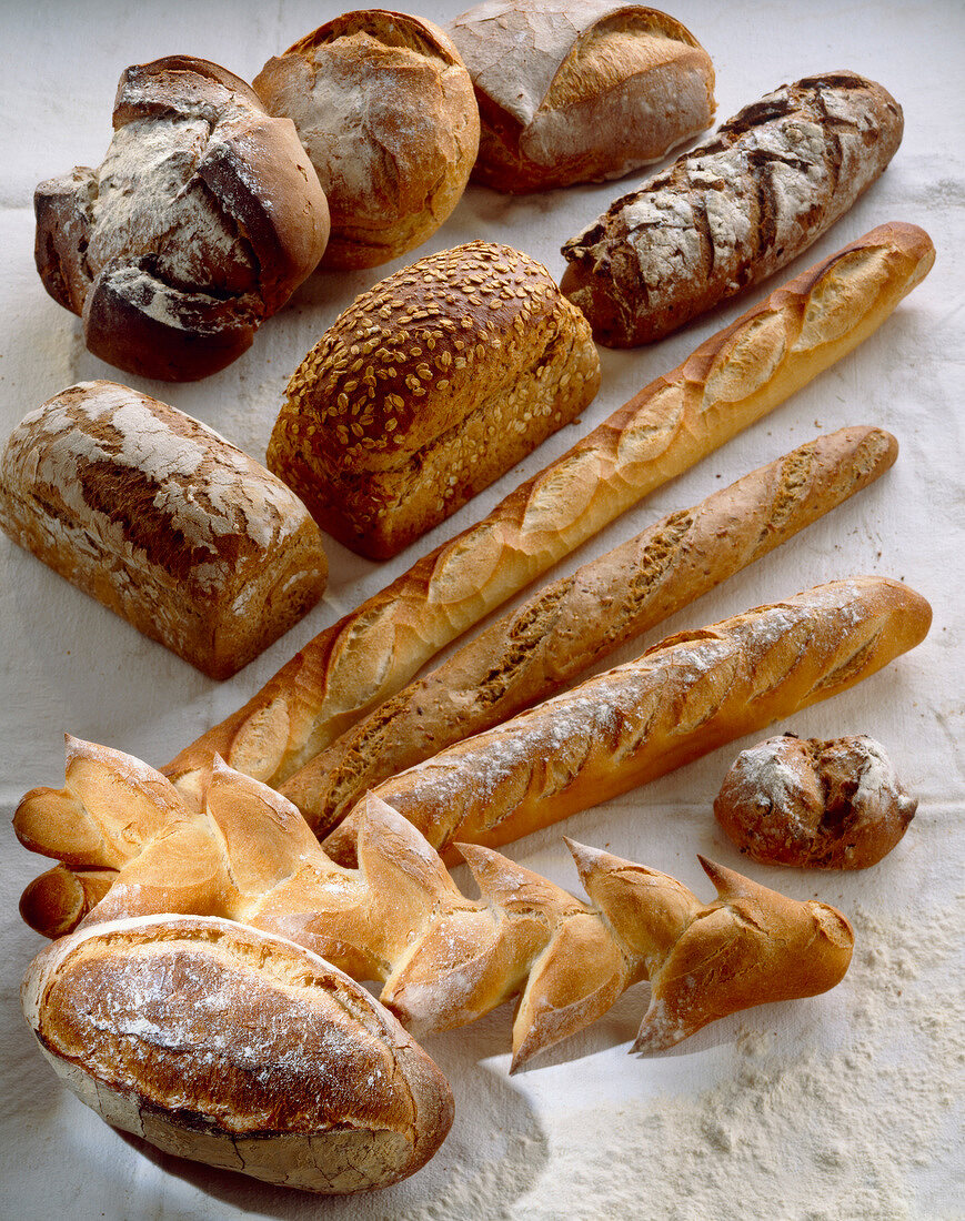 Verschiedene Brotsorten auf weißem Untergrund mit Mehl