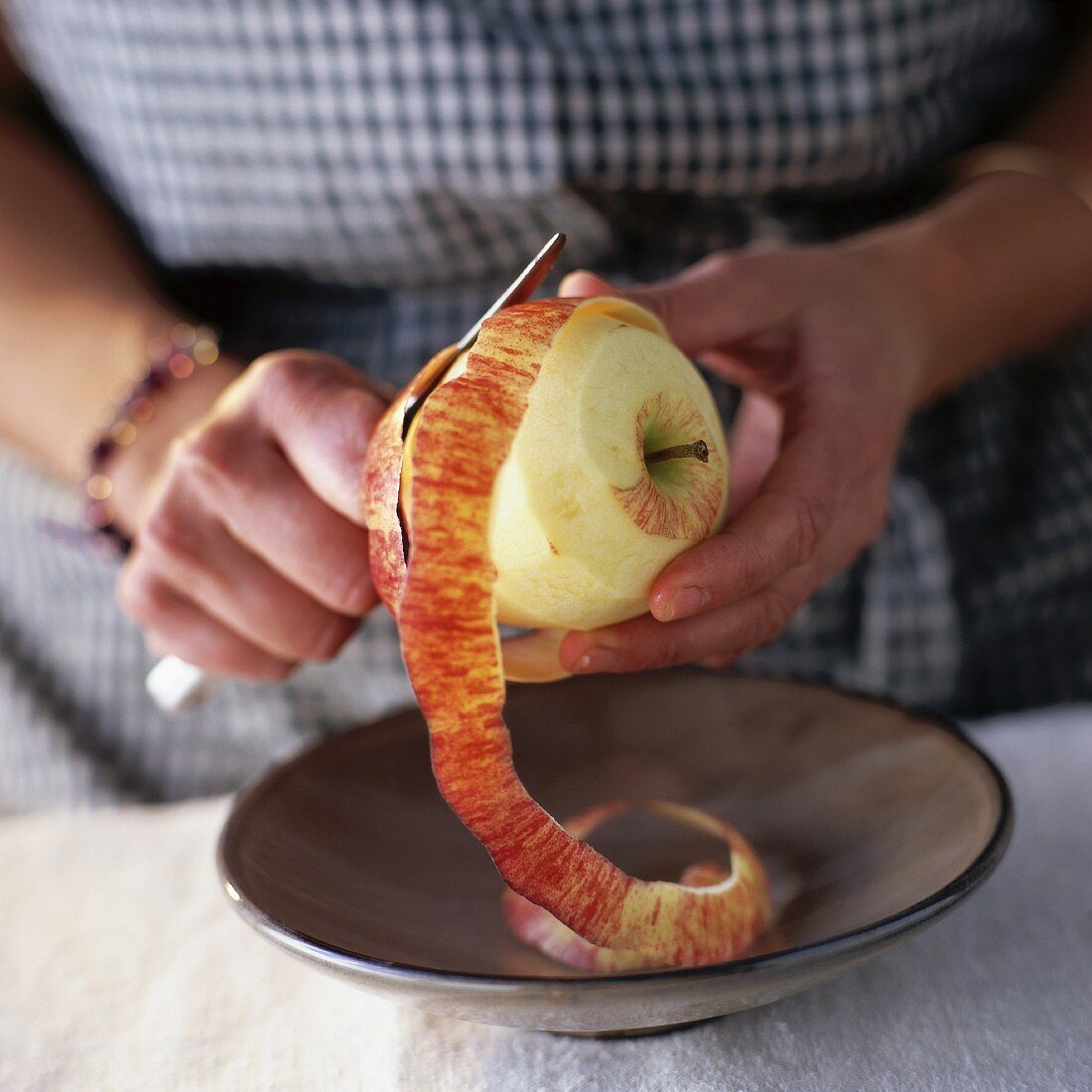 Frau schält einen Apfel