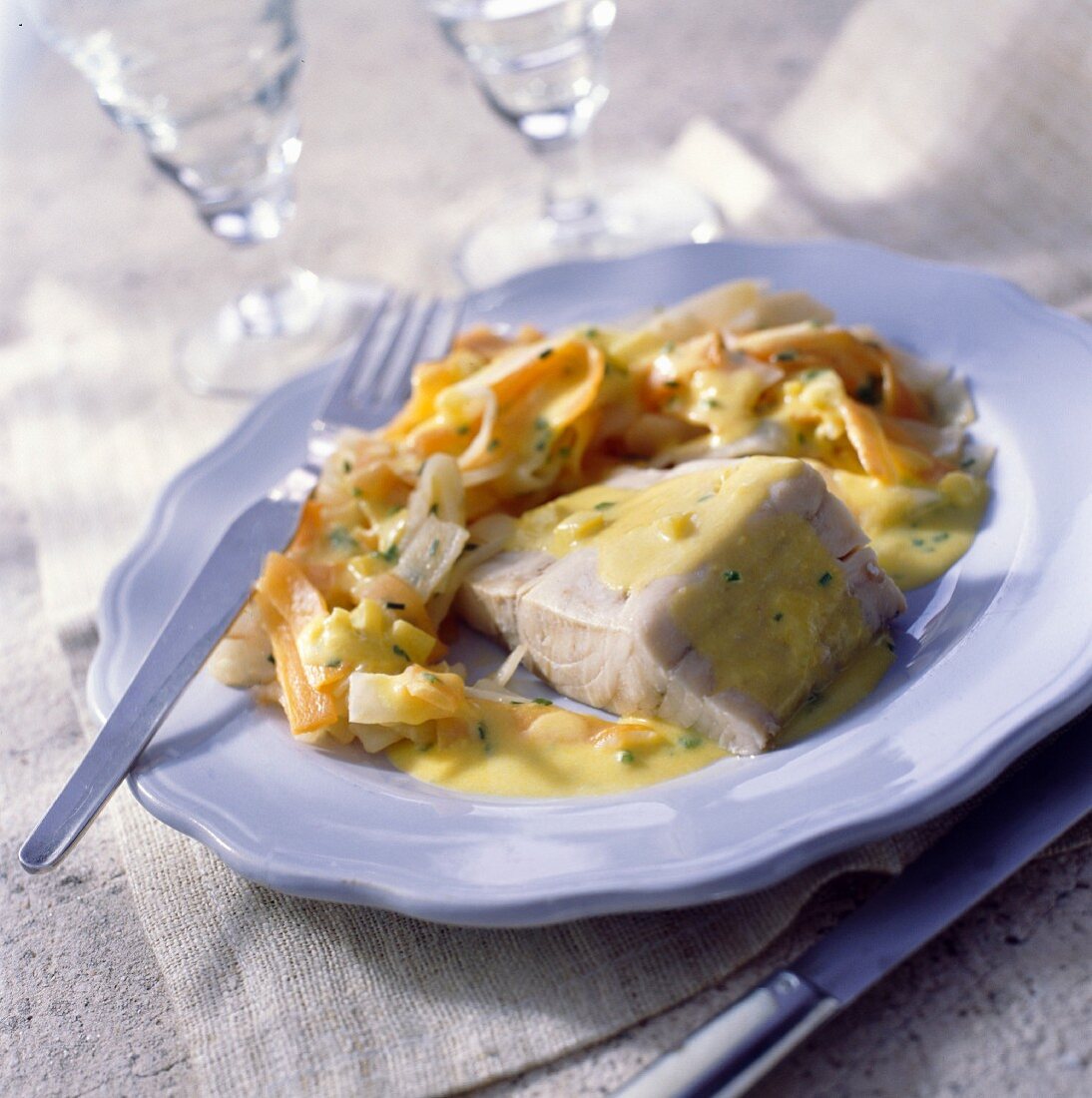 Hake fillet in saffron-flavored sauce with mess of vegetables