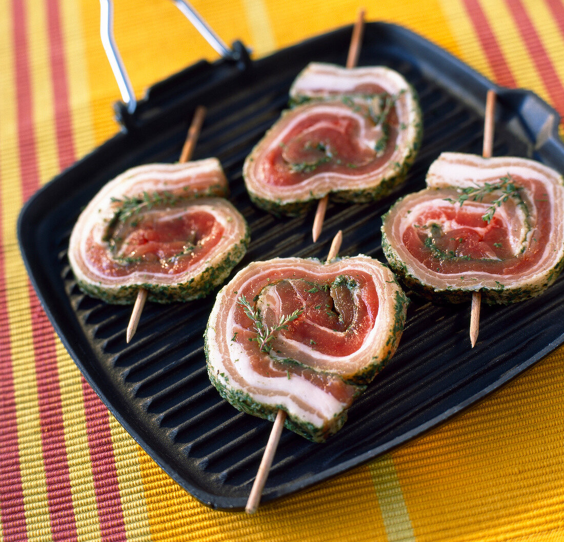 Rolled pork kebabs on grill