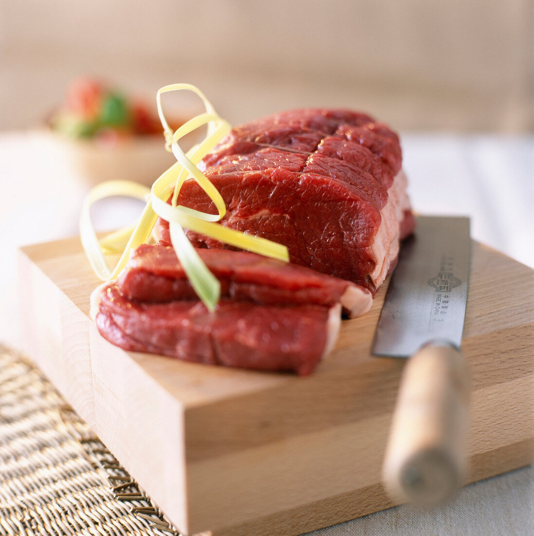 Raw roasting beef on chopping board with knife