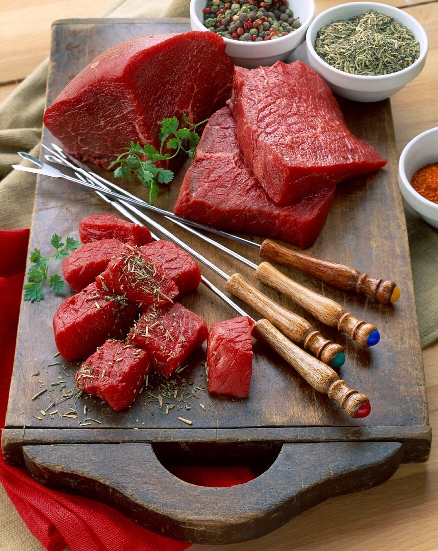 Rindfleisch am Stück und in Würfel geschnitten mit Kräutern und Gewürzen für ein Fondue