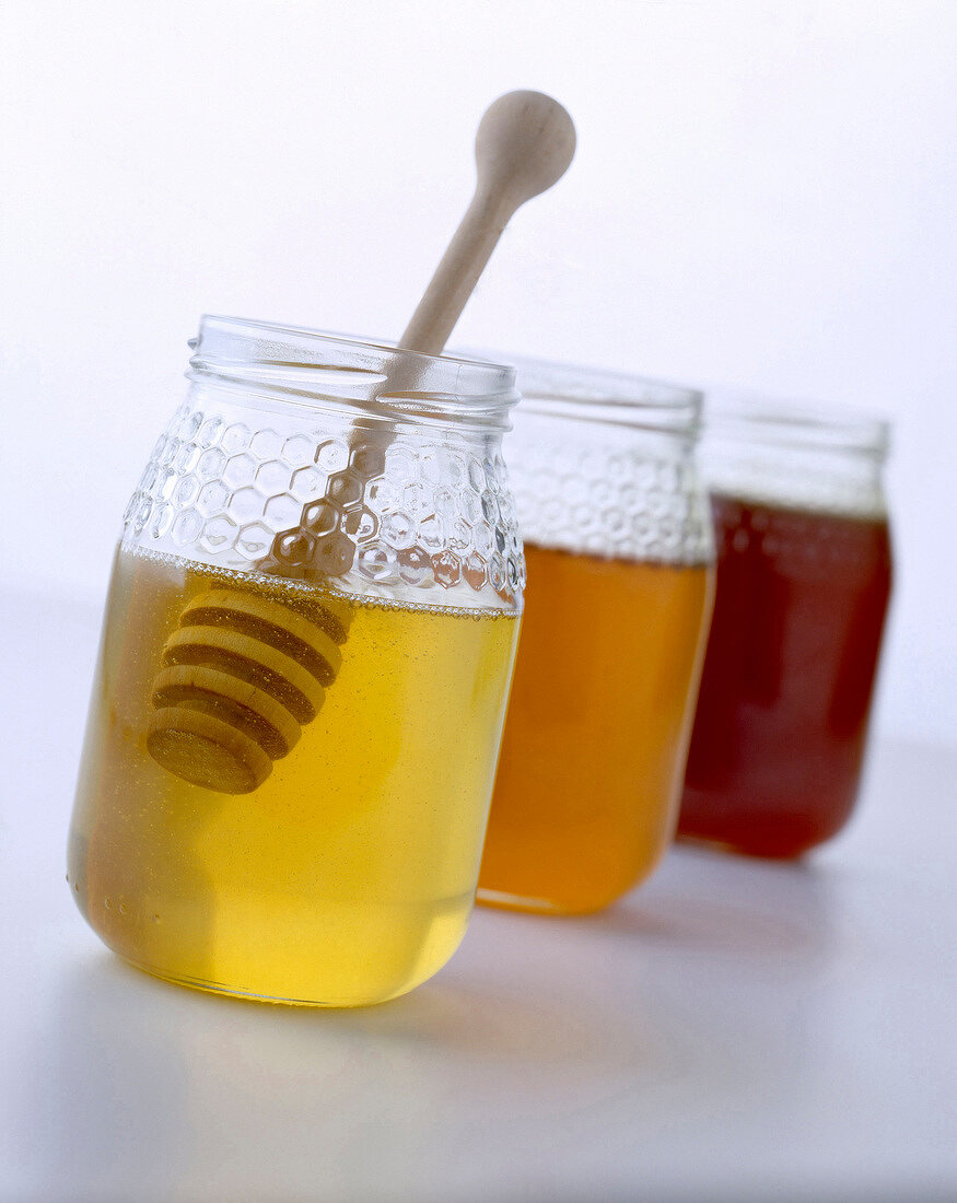 Drei Gläser mit verschiedenen Honigsorten