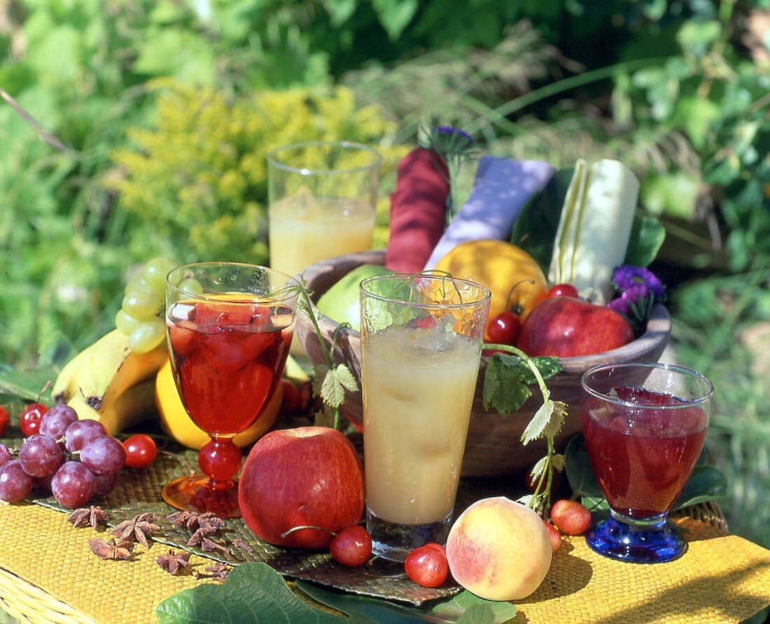 Fruchtsäfte und Obst auf einem Tisch im Freien