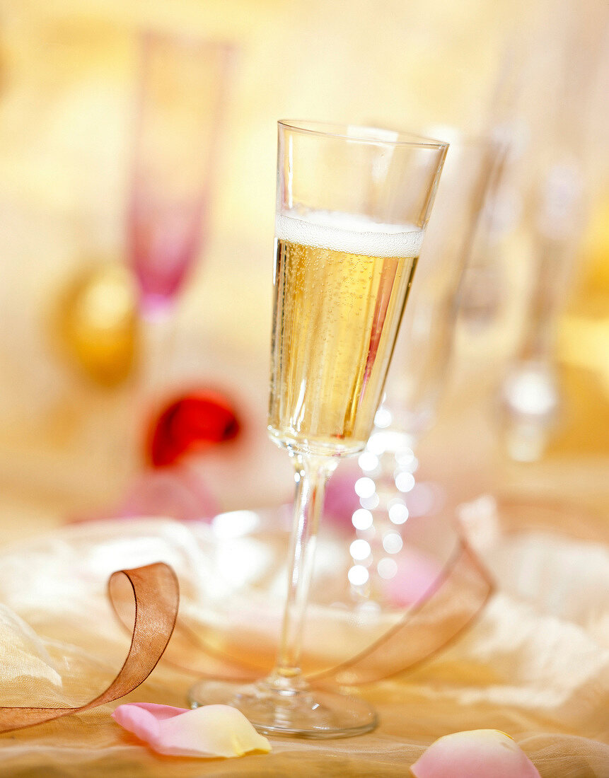Ein Glas Champagner mit festlicher Deko