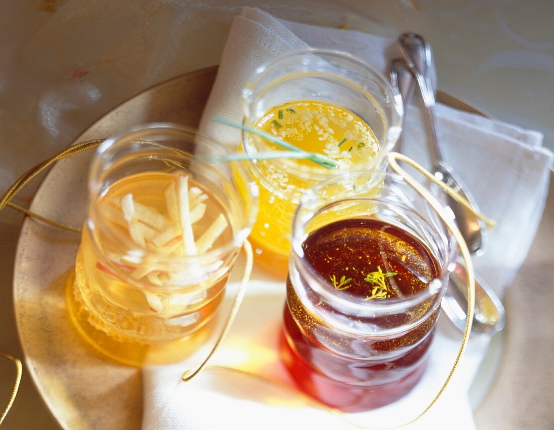 Aromatisiertes Öl und Essig in drei Gläsern