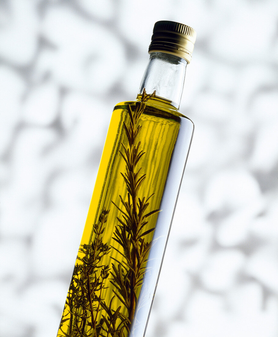 Olivenölflasche mit frischen Kräutern