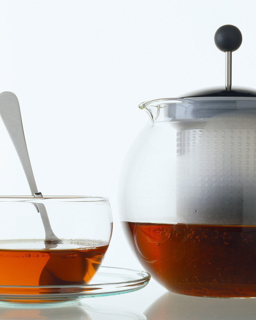 Glastasse mit Tee und Teekanne