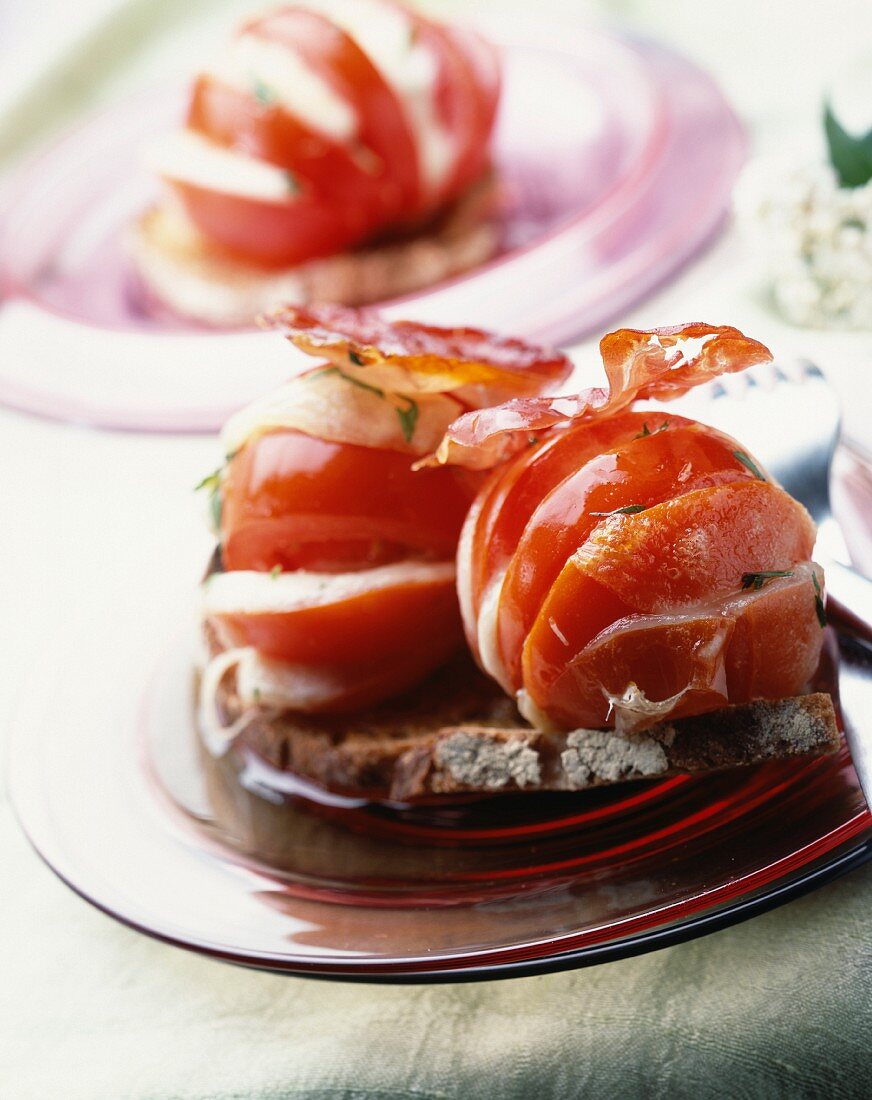 Tomate mit Mozzarella und Speck auf Brotscheiben