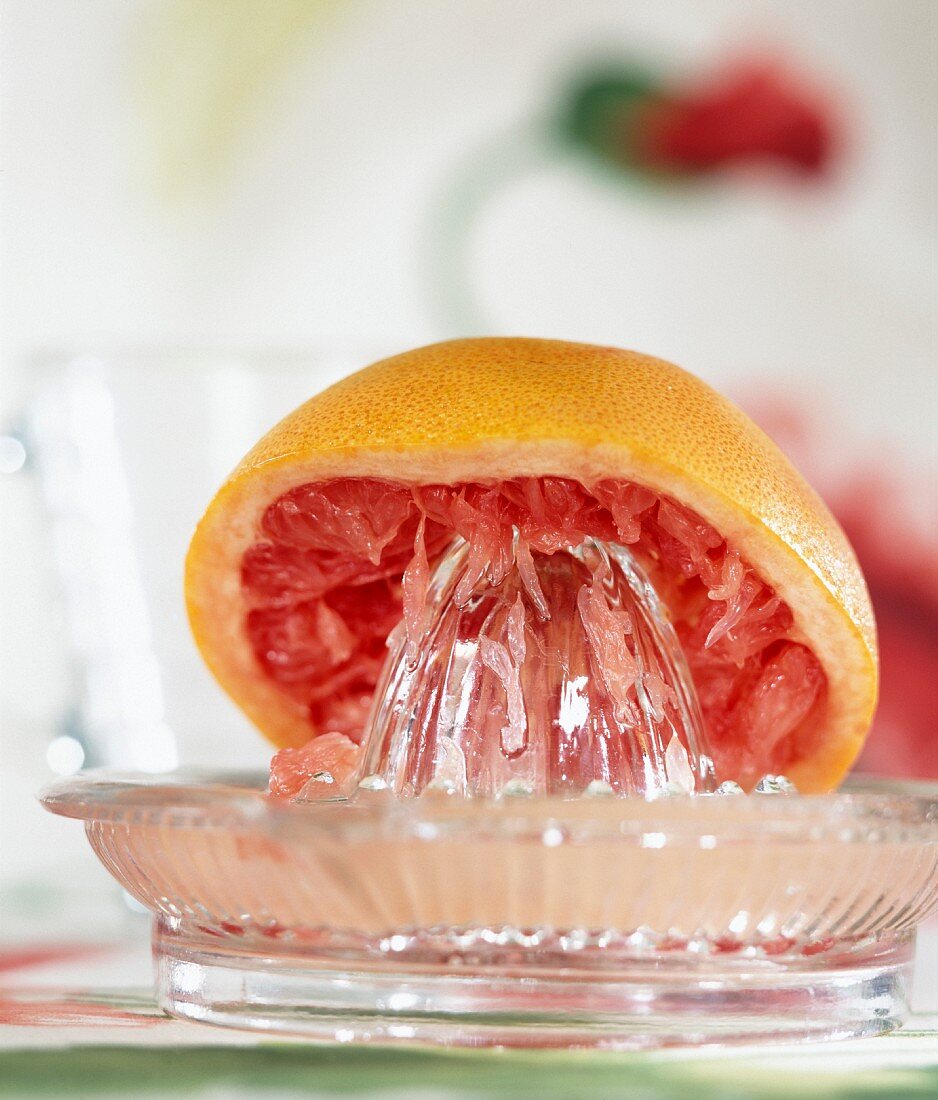 Grapefruithälfte und Saftpresse