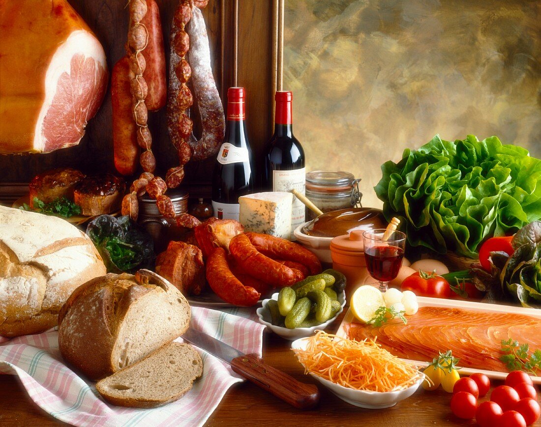 Stillleben mit französischen Lebensmitteln (Wurst, Brot, Wein, Lachs etc.)