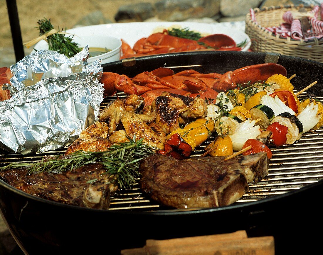 Hummer, Steak, Hühnchen und Gemüse auf einem Grill