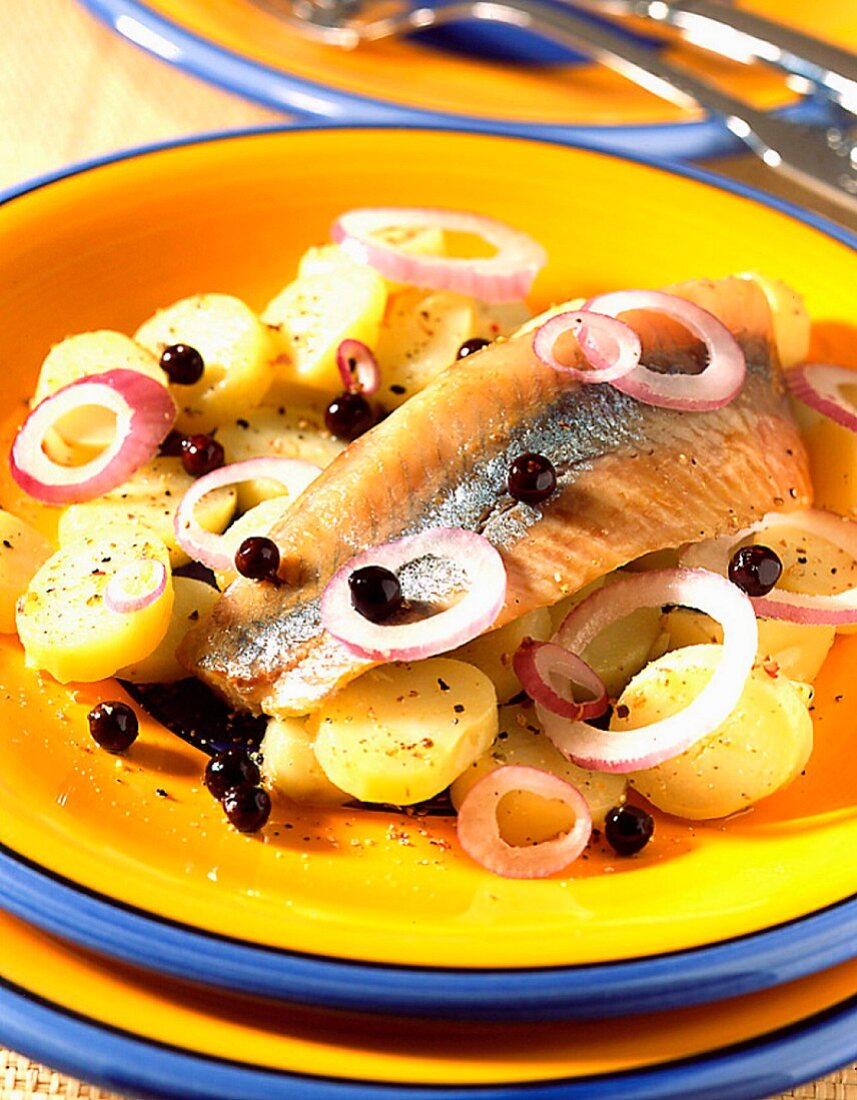 Marinated herring in oil with potatoes and juniper berries