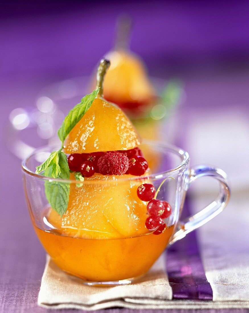 Stewed pear in syrup with summer fruit