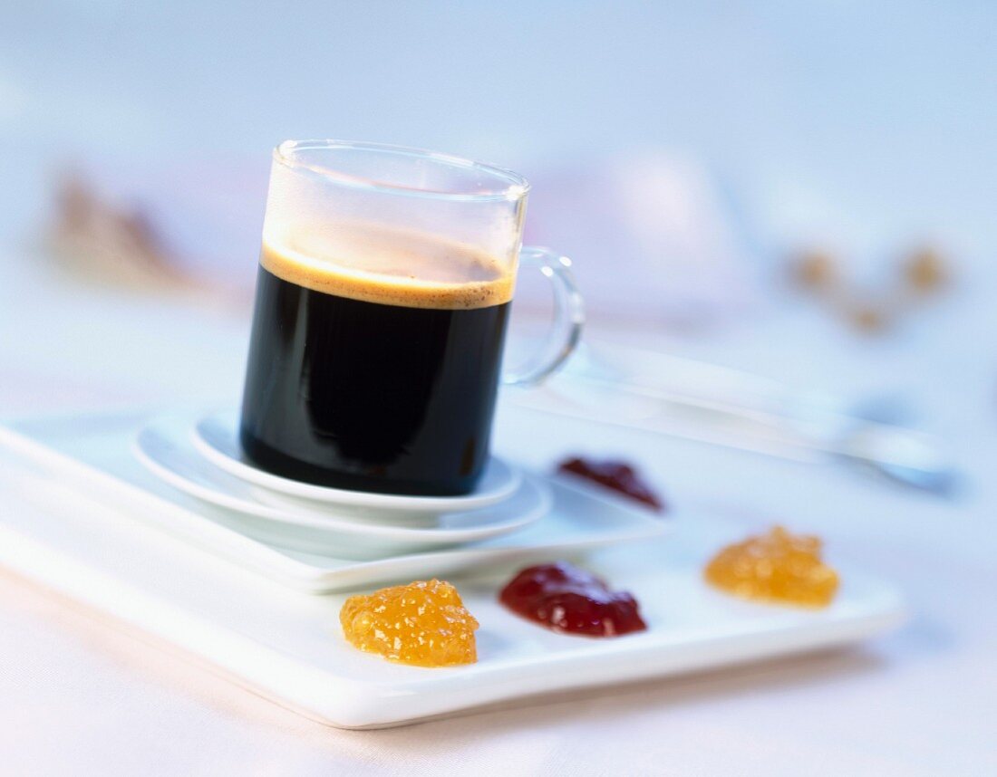 Tasse schwarzer Kaffee auf mehreren Tellern