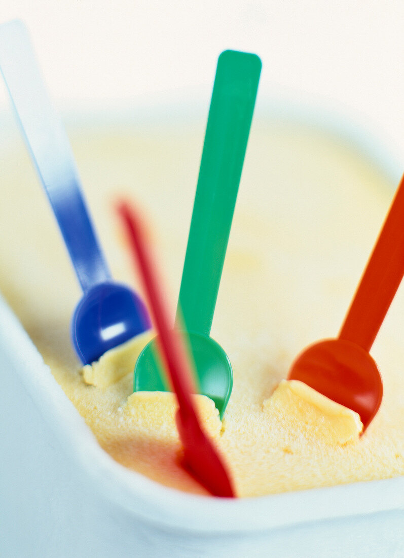 Liter tub of vanilla ice cream with colored plastic spoons