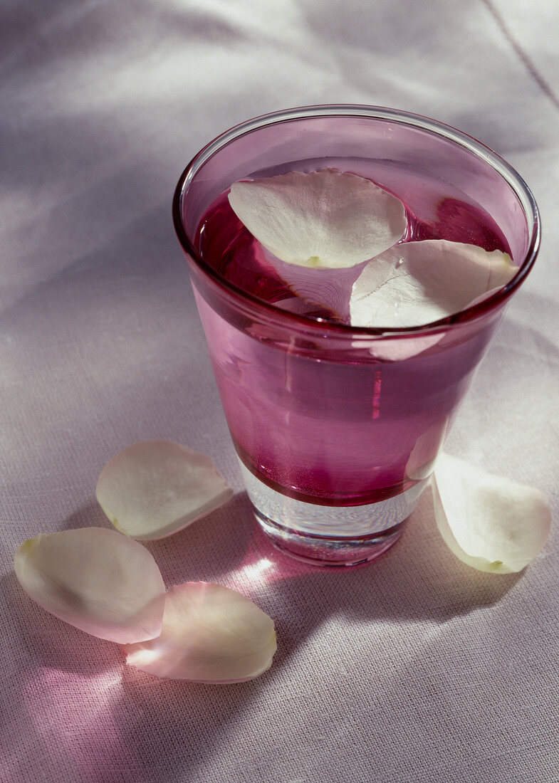 Rosenwasser mit Rosenblütenblättern