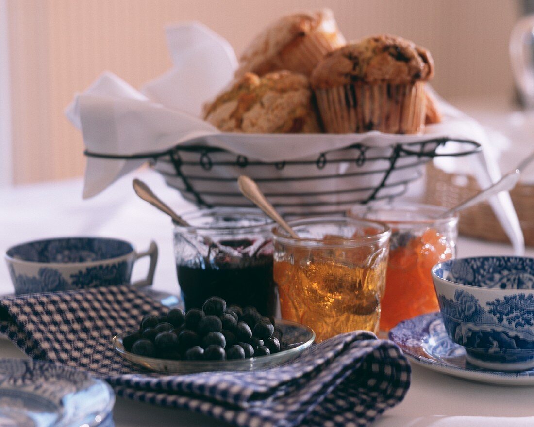 Assorted Muffins in a Wire Basket with Assorted Jams and Jellies