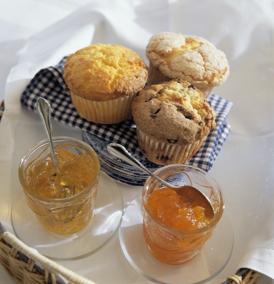 Drei Muffins auf blau-weisser Serviette; Marmeladen