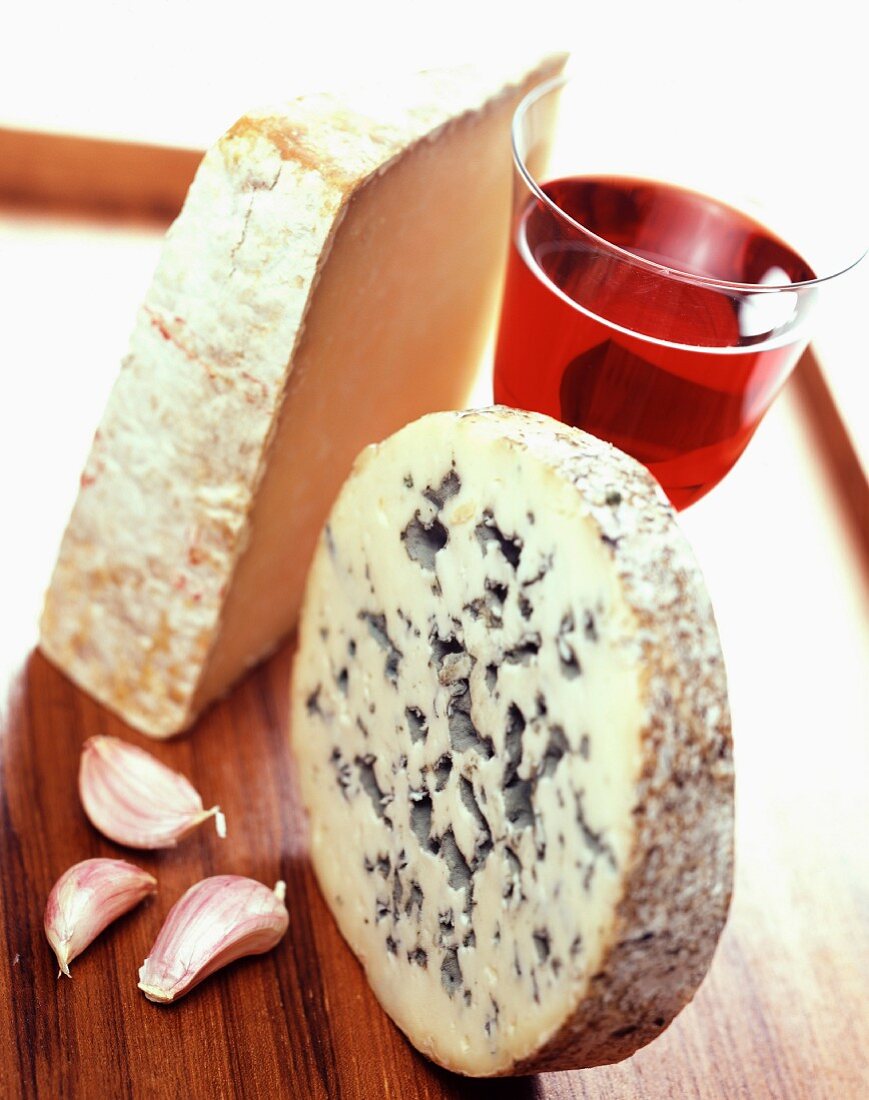Stillleben: Käse mit Knoblauchzehen und Rotwein