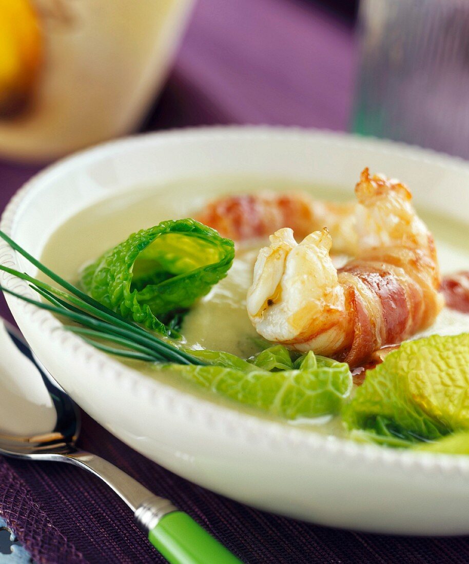 Creamed cabbage soup with langoustine prawns wrapped in bacon