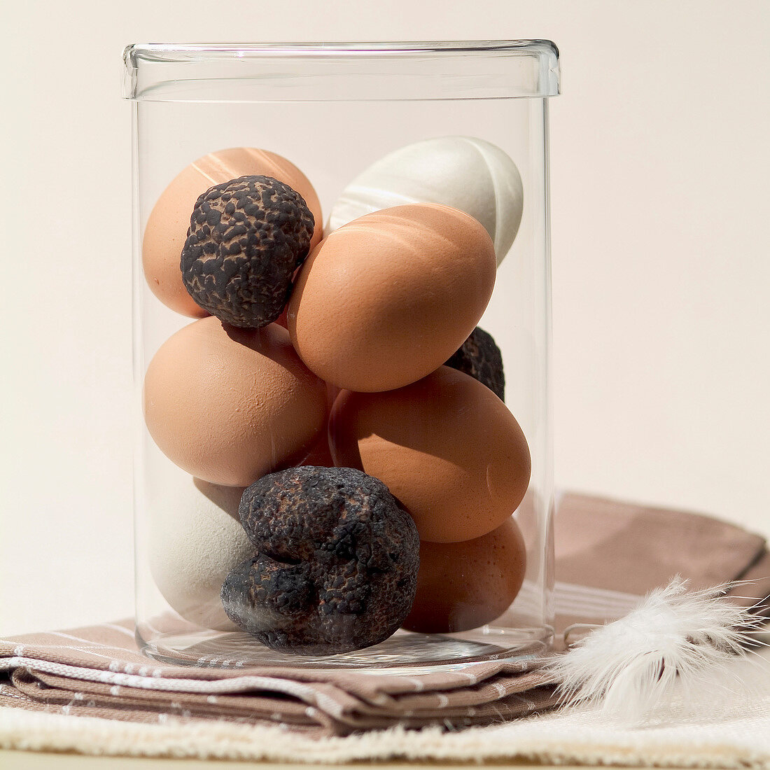 White and brown eggs with black truffles in jar