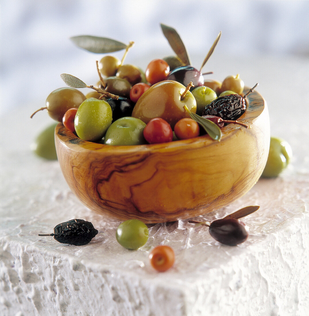 Verschiedene Oliven in einer Schale aus Olivenholz
