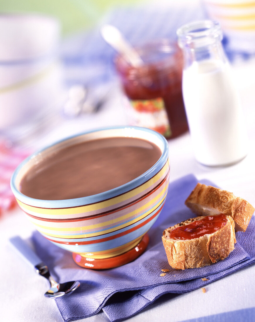 Heiße Schokolade in einer Schale mit Marmeladenbaguette zum Frühstück