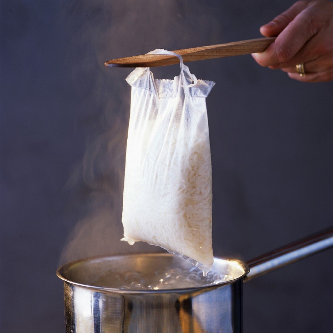 Lifting sachet of cooked rice from pan