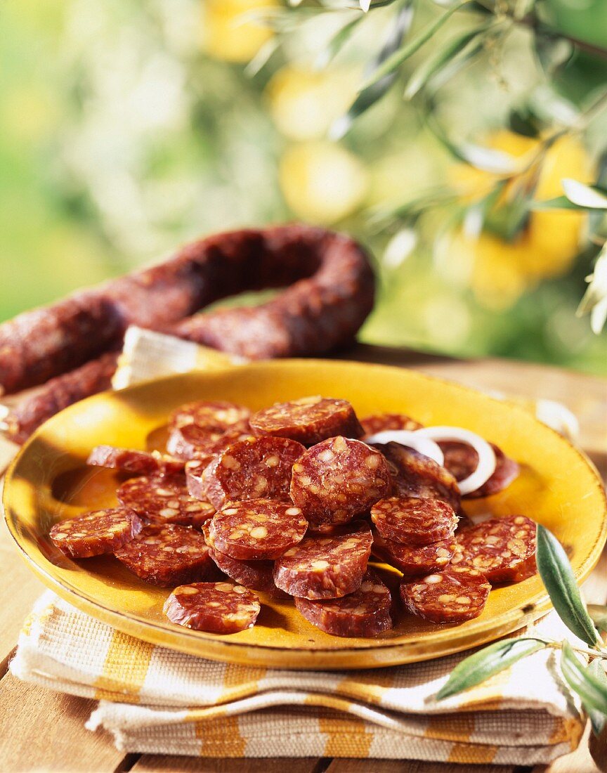 Chorizoscheiben mit Zwiebelringen auf Teller