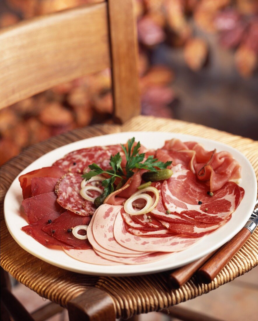 Wurst- und Schinkenplatte auf einem Stuhl