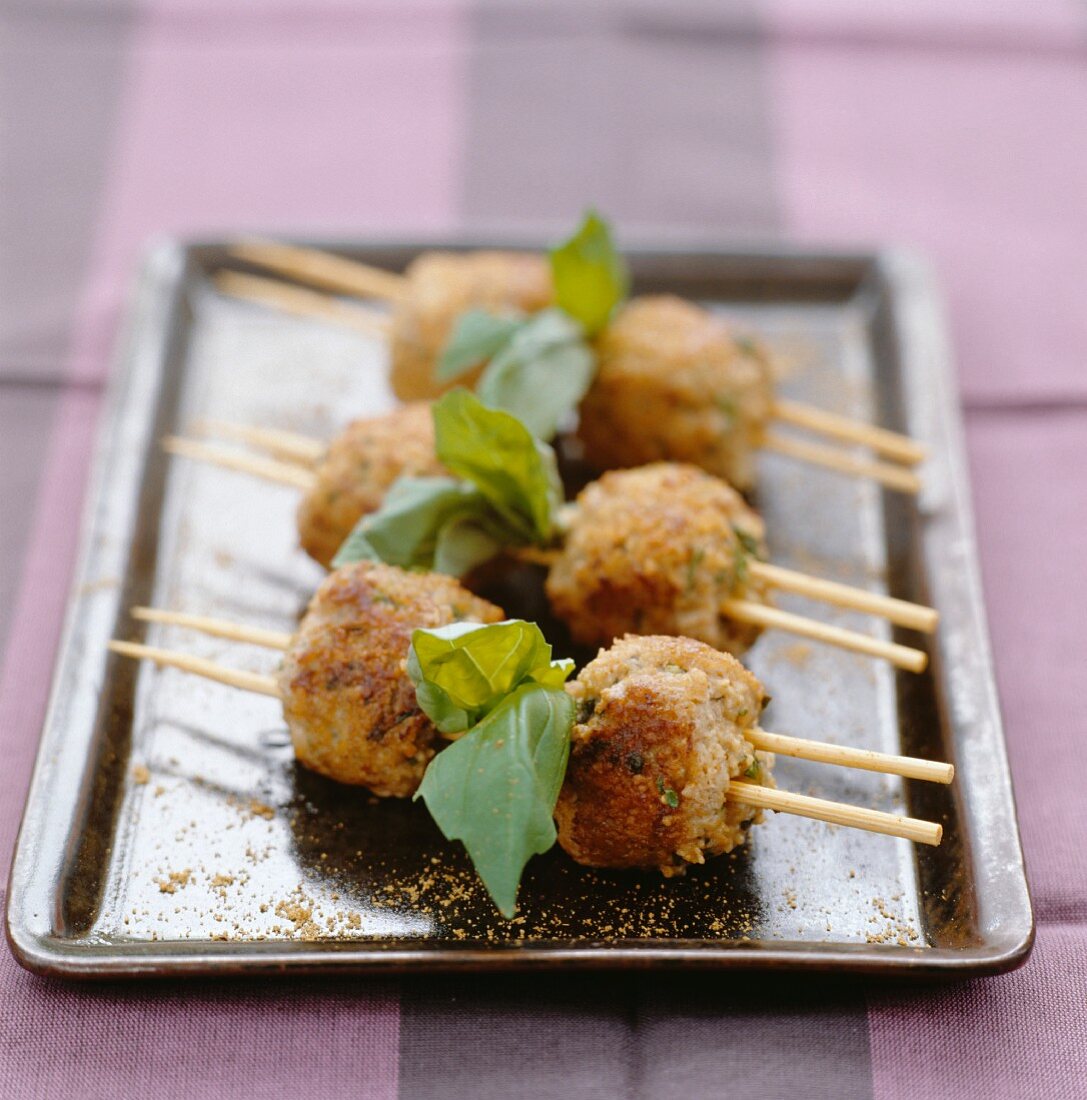 Drei Spiesschen mit Geflügelbällchen und Kräutern