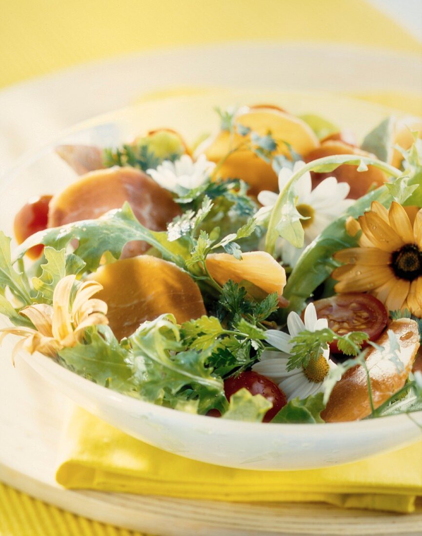 Salat mit Essblüten und Parmaschinken