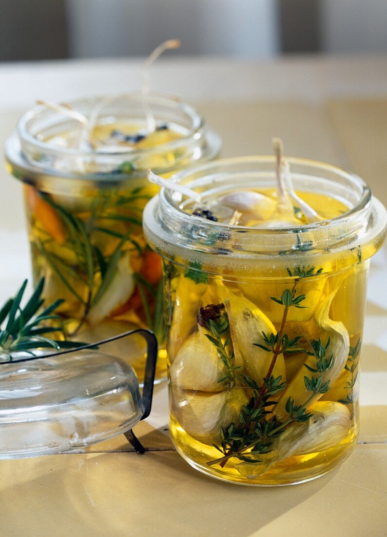 Garlic marinating in oil with rosemary and thyme