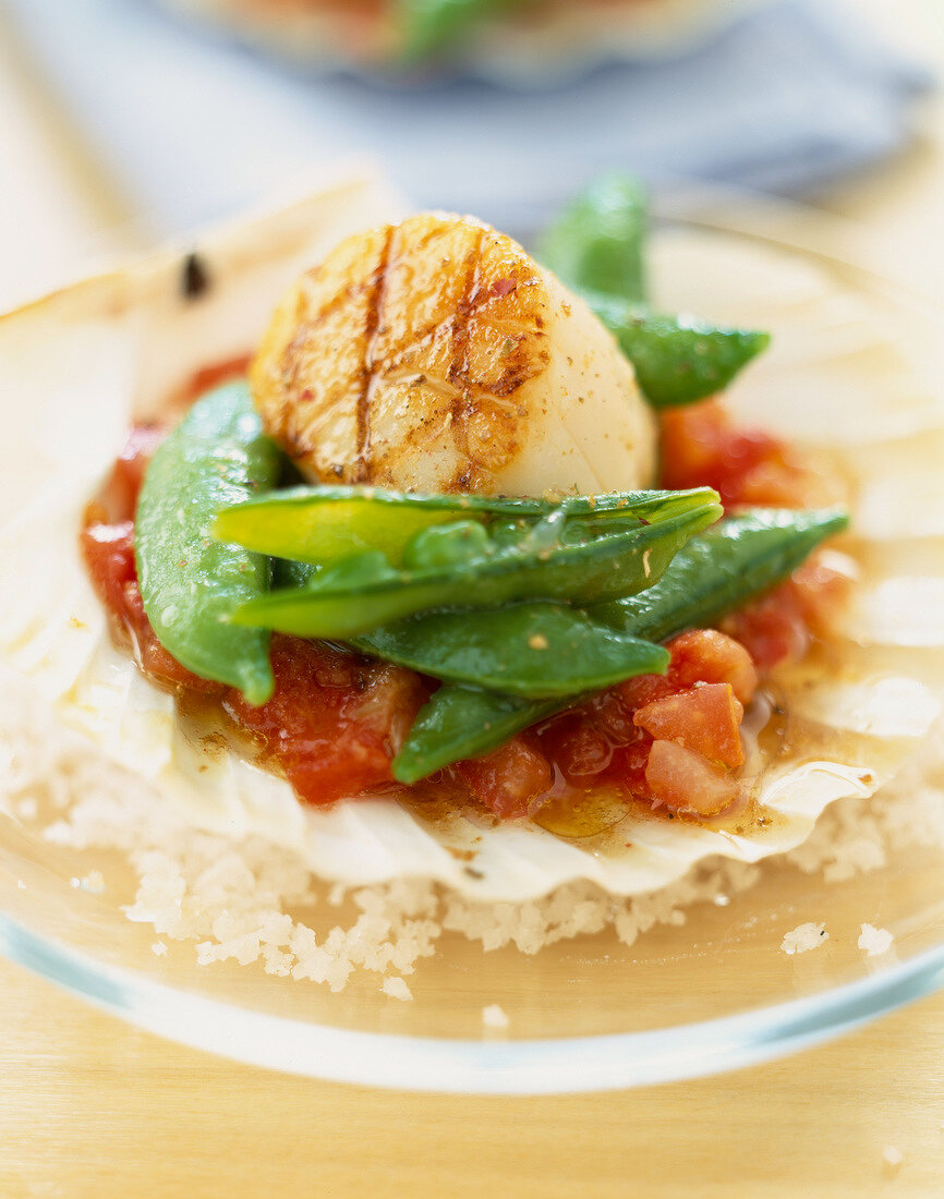 Scallops with peas with their pods and crushed tomatoes