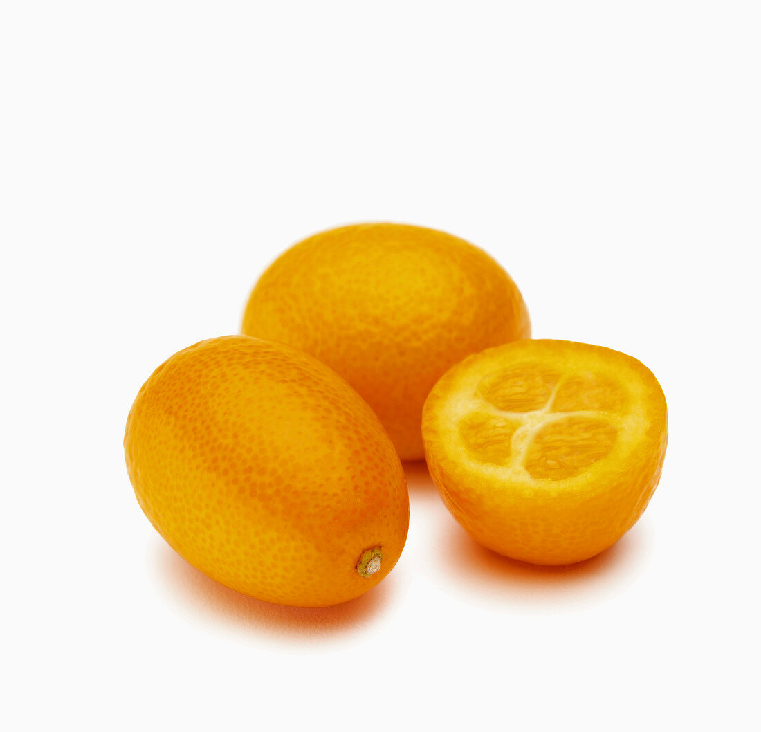 Drei Kumquats, eine halbiert