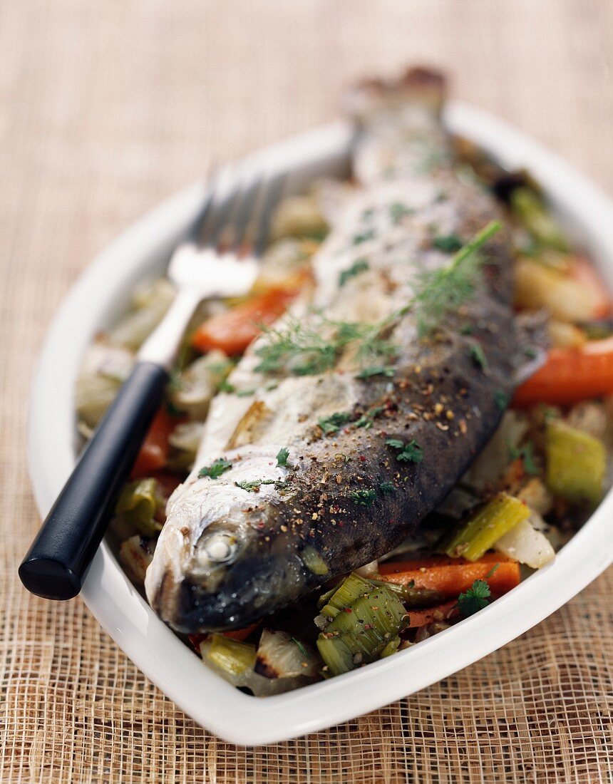 Trout cooked in the oven on a bed of fennel and capers