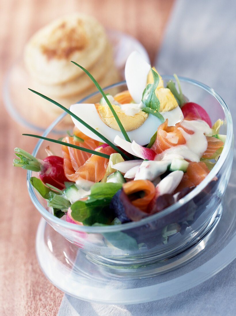 Salat mit Lachs und Ei in einem Glasschälchen