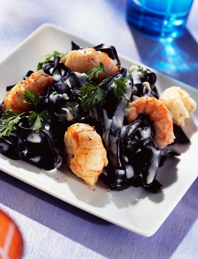 Squid ink spaghettis with scampis and herbs
