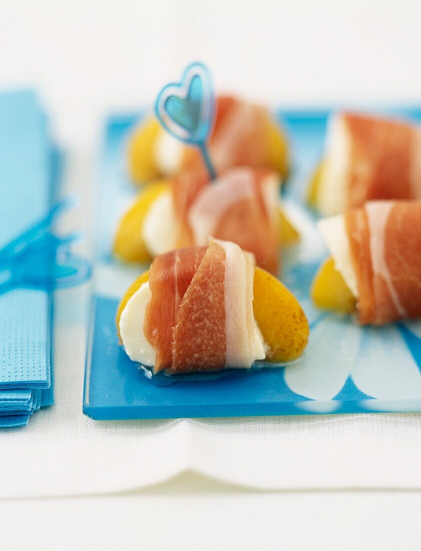 Sliced peaches wrapped in raw ham