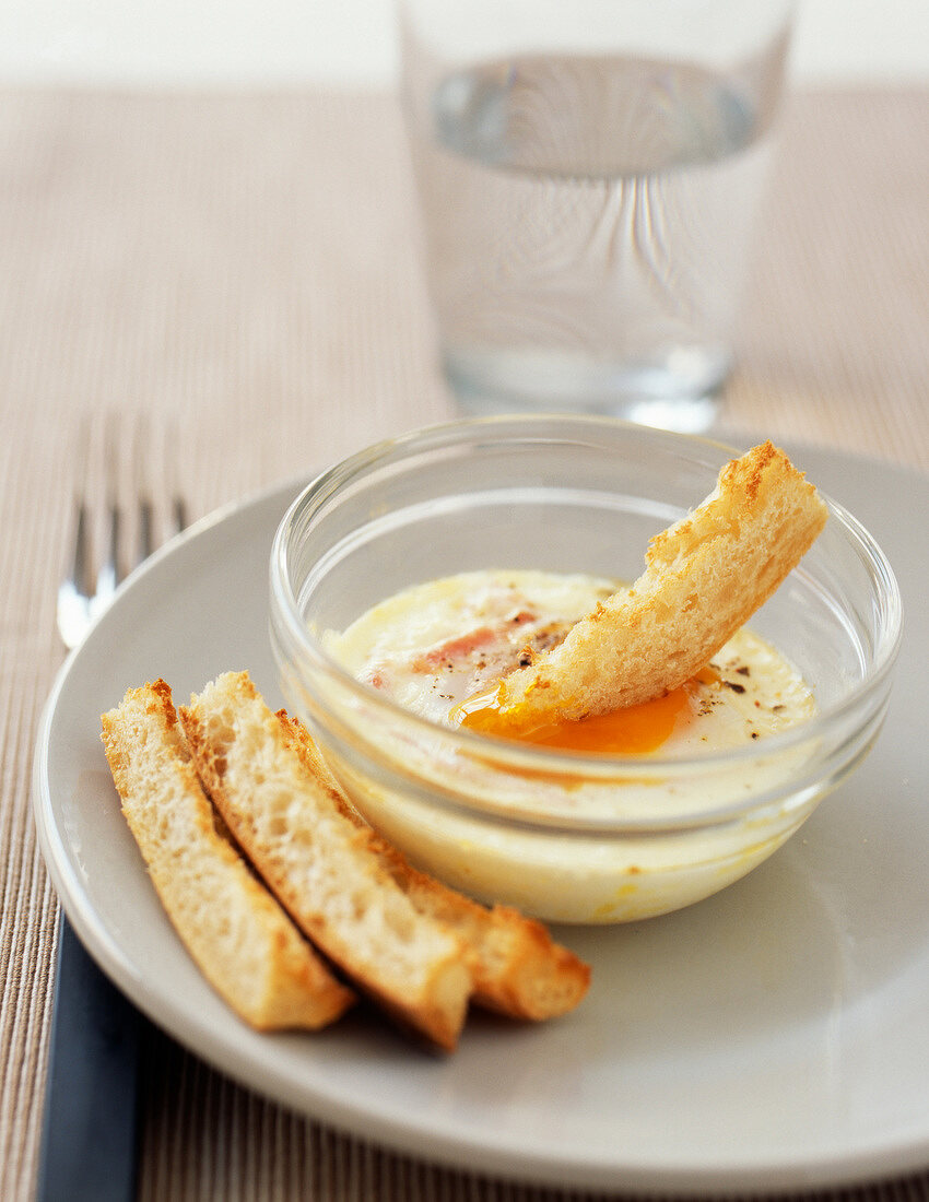 Coddled egg with ham and soldiers