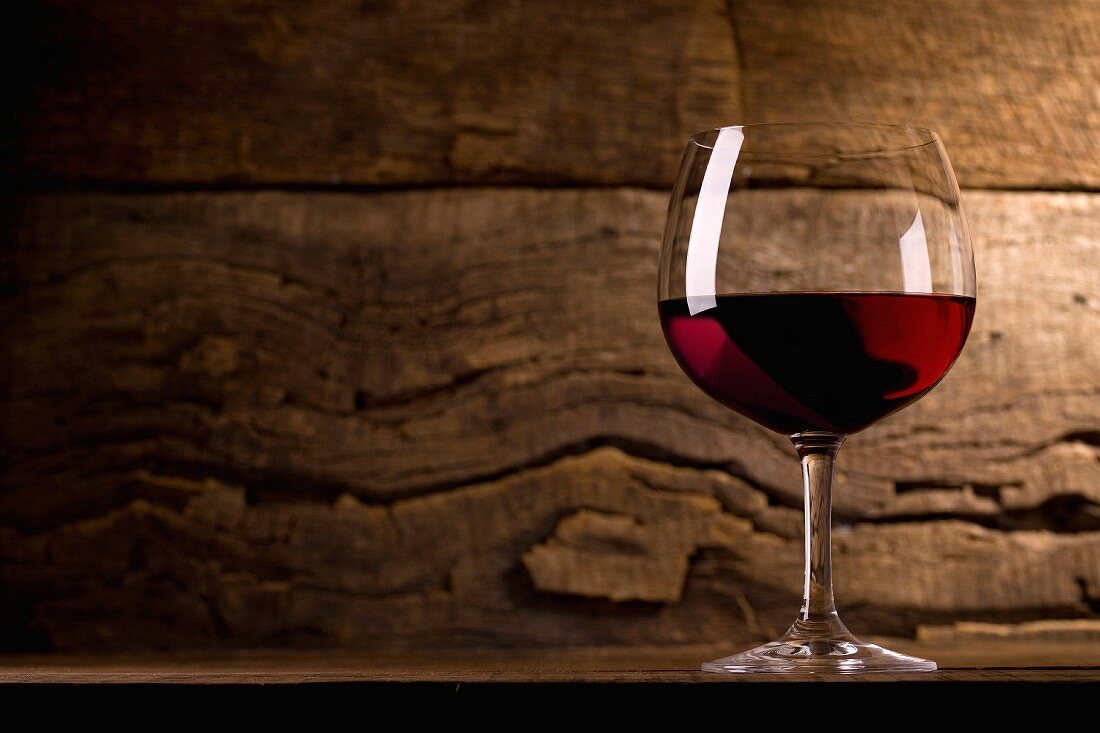 Ein Glas Rotwein auf Holzuntergrund