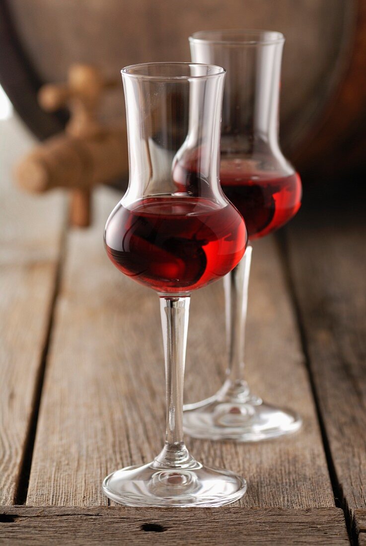 Rotweingläser mit Weinfass im Hintergrund
