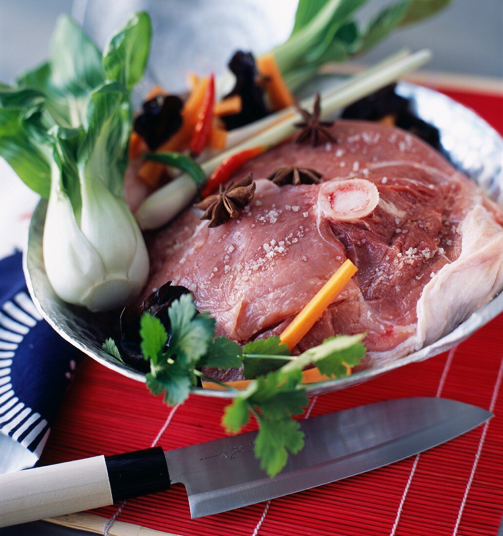Raw thick round salt pork fillet with vegetables