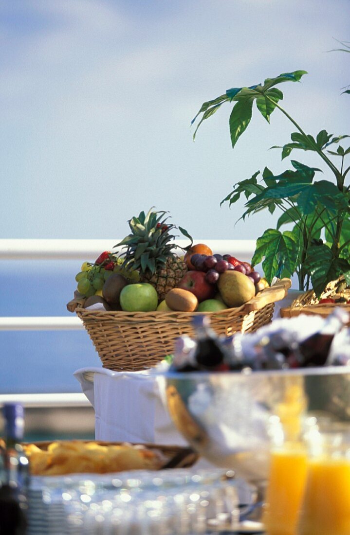 basket of fruit on a table by the sea