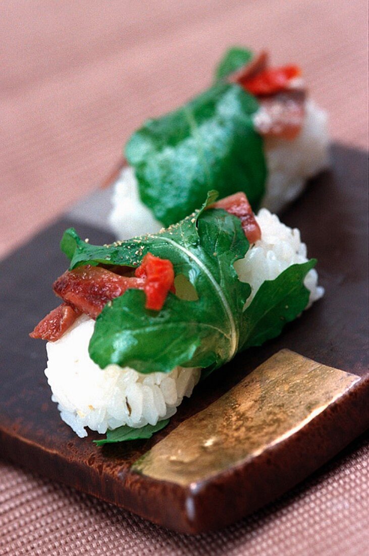 Nigiri Sushi mit Rucola und gebratenem Speck
