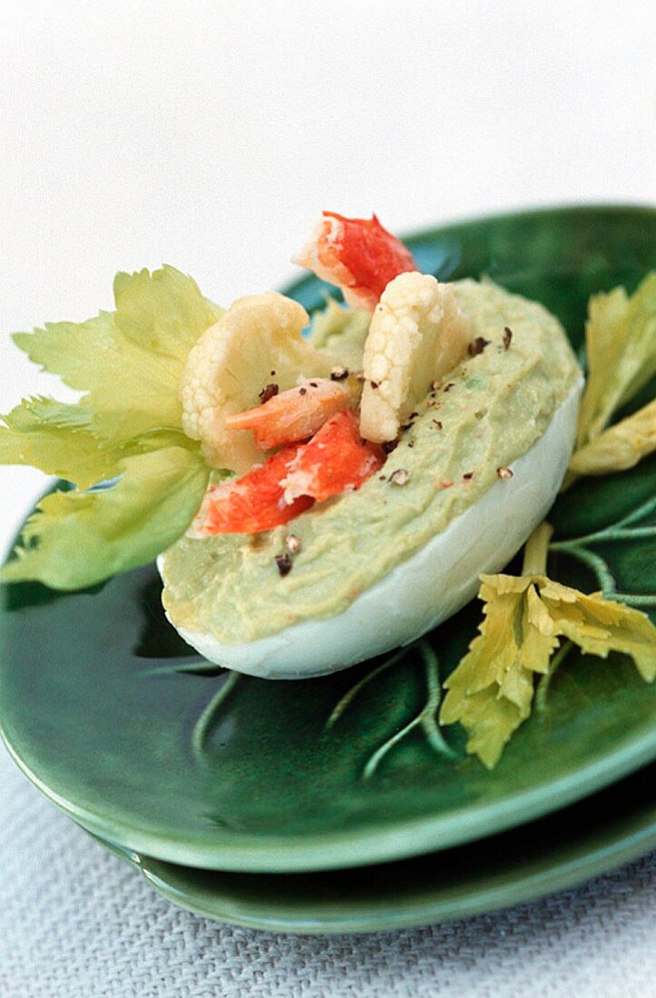 A devilled egg with avocado cream and shrimps